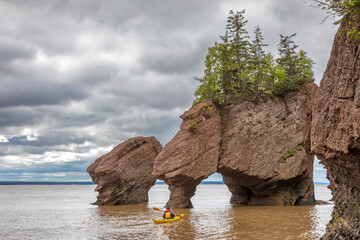 Kayaking at The flowerpot rock formations at Hopewell Rocks, Bay of Fundy, New Brunswick. The extreme tidal range of the bay makes them only accessible at low tide. - 750676654