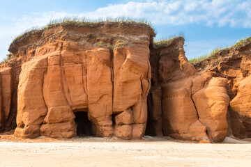 The red cliffs and beach of Havre aux Maisons, on the Gulf of St Lawrence, Magdalen Islands, Canada. Blue sky background.