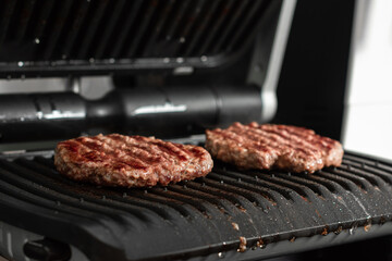 Juicy beef patty for burgers on a hot grill