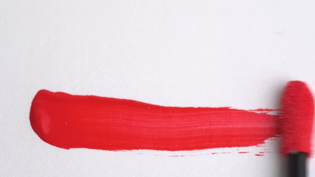 Lipgloss make-up smudge, smear. Classic red lipstick, lip gloss texture smear smudge swatch sample. Lipstick smear in trendy deep red colo