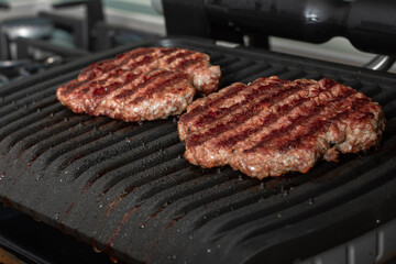 Freshly grilled burger meat. Burgers on the grill. Cooking burgers on hot grill