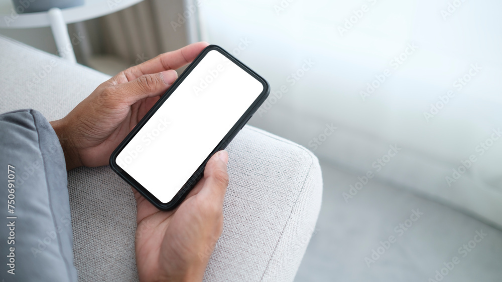 Poster closeup man using mobile phone while lying on couch. white empty screen for your advertising.