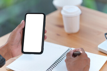 Man holding mock up smart phone. Blank screen for your text message or information content.