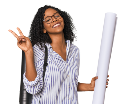 Young African American architect with blueprint joyful and carefree showing a peace symbol with fingers.