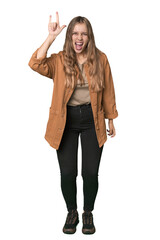 Fototapeta premium Studio portrait of a blonde Caucasian woman showing a horns gesture as a revolution concept.