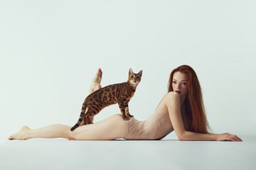 Passion and tenderness. Young redhead beautiful girl with long hair, slim body lying on floor with...