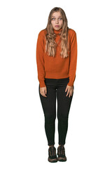 Fototapeta premium Studio portrait of a blonde Caucasian woman shrugs shoulders and open eyes confused.
