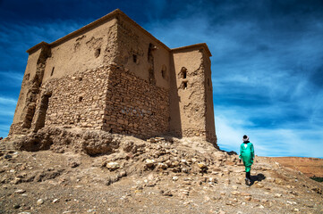 Man walking past historic building in Ait Benhaddou, Morocco - 750697487