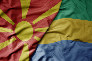 big waving national colorful flag of gabon and national flag of macedonia .