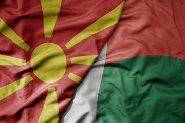 big waving national colorful flag of madagascar and national flag of macedonia .