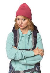 Middle-aged Caucasian woman with hiking gear frowning face in displeasure, keeps arms folded.