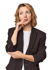 Caucasian woman in black business suit looking sideways with doubtful and skeptical expression.