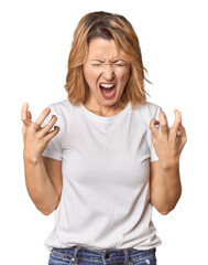 Blonde middle-aged Caucasian woman in studio screaming with rage.