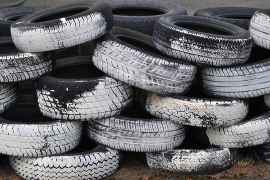 Stack of Old White Painted Car Tires beside Race Track 