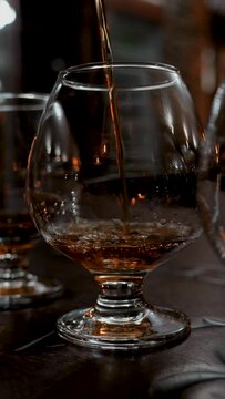 This stock video shows how cognac is poured into a glass glass. This video will decorate your projects related to alcohol, alcoholic beverages, tasting, holidays.