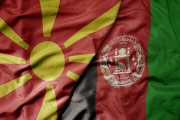 big waving national colorful flag of afghanistan and national flag of macedonia .