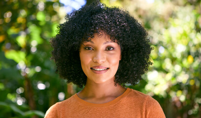 Head And Shoulders Portrait Of Smiling Confident Mid Adult Woman Standing Outdoors