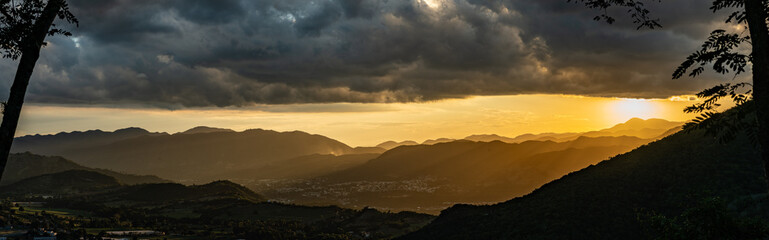 Dramatic panoramic image of the Caribbean mountains at sunset with fading mountains in the...