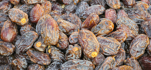 Closeup of dried dates as a background. Dried, medjool dates as a background, closeup. Textured dried dates..