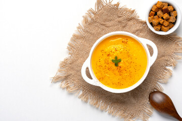 Pumpkin soup with croutons on white background, with copy space for text