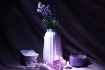 Relax still life. Candle, lavender and delicate flower petals. Violet background. Spa relax