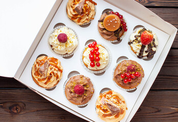 Vanilla, chocolate and peanut butter cupcakes with salted caramel, fresh raspberry, strawbeery and red currant in gift paper box