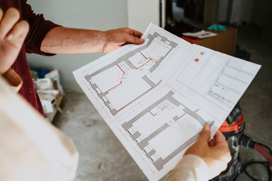 Cropped image of couple discussing over blueprint while renovating home