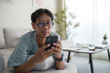 Happy young man checking social media or shopping online on smart phone.