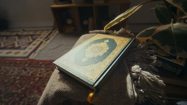 No people footage of holy book Quran in dark green hard cover decorated with golden ornaments lying on coffee table at home
