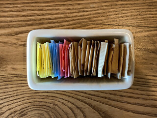 Ceramic holder for sugar and sugar substitute packets filled with all the colors