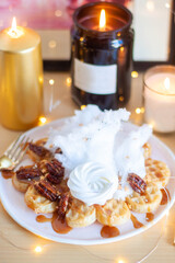 Belgian waffles with maple syrup and pecan on a wooden table, breakfast, no people, close up