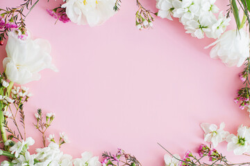 Obraz na płótnie Canvas Happy Mothers day and Womens day. Stylish white flowers flat lay on pink background, space for text. Beautiful tender tulips and spring flowers frame, greeting card template. Floral banner
