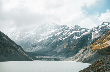 A snow-capped peak landscape scene with a lake at Hooker Valley, Mount Cook, New Zealand.