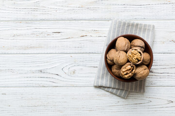 Fresh healthy walnuts in bowl on colored table background. Top view Healthy eating bertholletia...