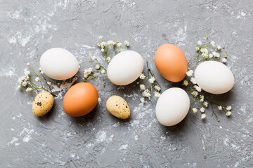 Happy Easter composition. Easter eggs on colored table with gypsophila. Natural dyed colorful eggs...