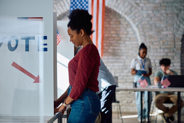 Black woman at voting booth during US elections.