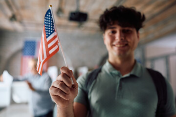 Close up of US citizen holding national flag while voting at polling station.