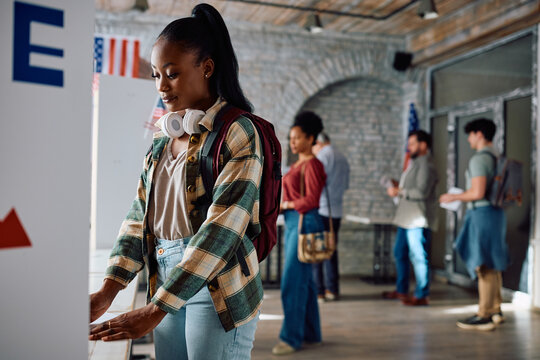 Young black woman at voting booth during United States of America elections.