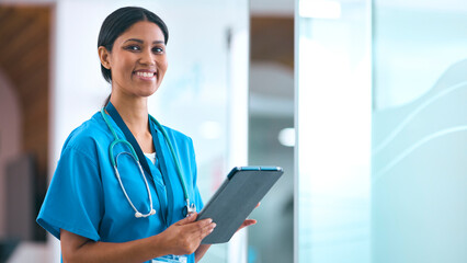 Portrait Of Female Doctor Or Nurse With Digital Tablet Checking Patient Notes In Hospital - 750749691