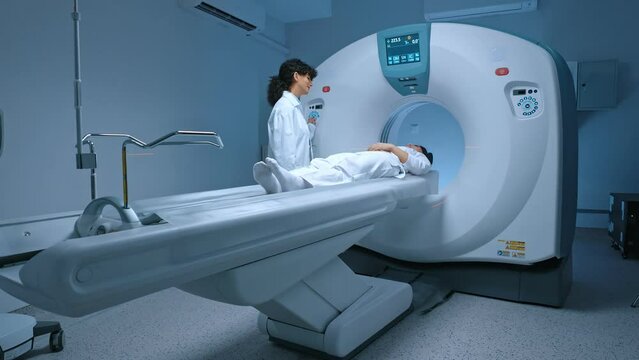 Patient in white clothes undergoes magnetic resonance imaging scan, laying down on bed for CT or PET scan, oncology machine scanning her body. Magnetic resonance diagnostics x-ray.