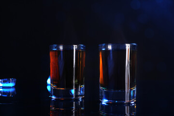 Alcohol drink in shot glasses on mirror surface
