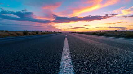 Asphalt road, orange sunrise, clouds