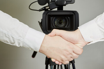 Hands shaking in front of a video camera, public contract,  public assurances of partnership,...
