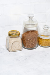 cereals in glass jars on a white background, vertical top view