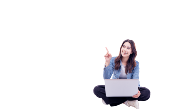 Happy young asian woman sitting on floor with legs crossed and using laptop computer isolated on white background copy space Full body young smiling happy female pointing up to copy space	