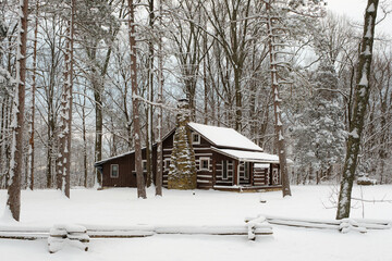 A cabin along the road in Brown County State Park. The ground and trees are covered in snow in the...