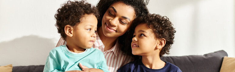 joyous african american woman hugging her cute little sons who holding present, Mothers day, banner