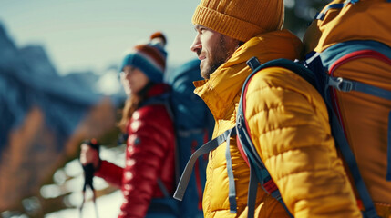 A man in a yellow jacket and a woman in a red jacket are standing on a snowy mountain - Powered by Adobe