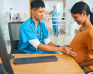Obraz premium Male Nurse Or Doctor Wearing Scrubs Examining Pregnant Woman In Hospital Obstetrics Clinic