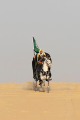 Saudi man in traditional clothing in the deset with a white horse